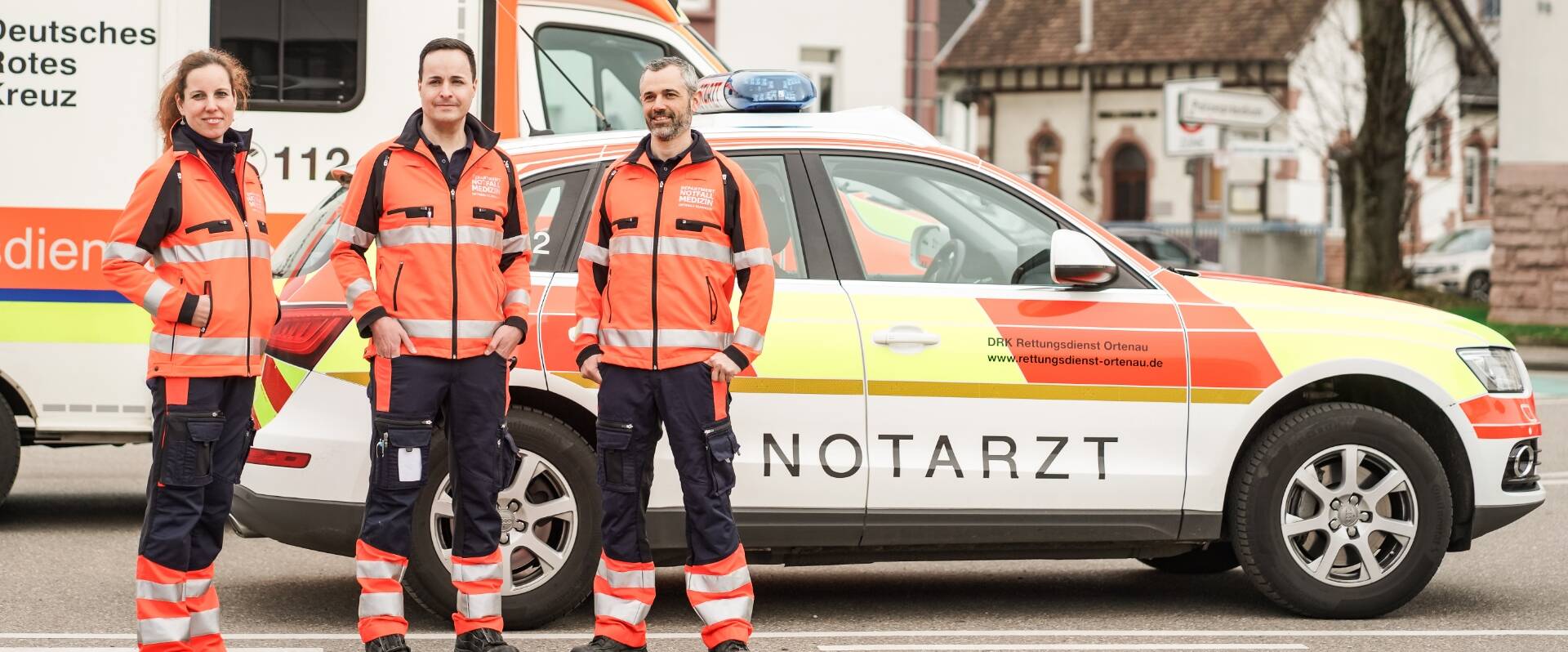 Teambild des Departments Notfallmedizin vor Notarztwagen